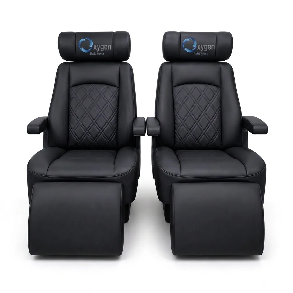 Two black quilted leather captain's chairs with extended footrests and embroidered Oxygen Health Systems headrest logos, shown front-on with diamond-stitched center panels and padded armrests